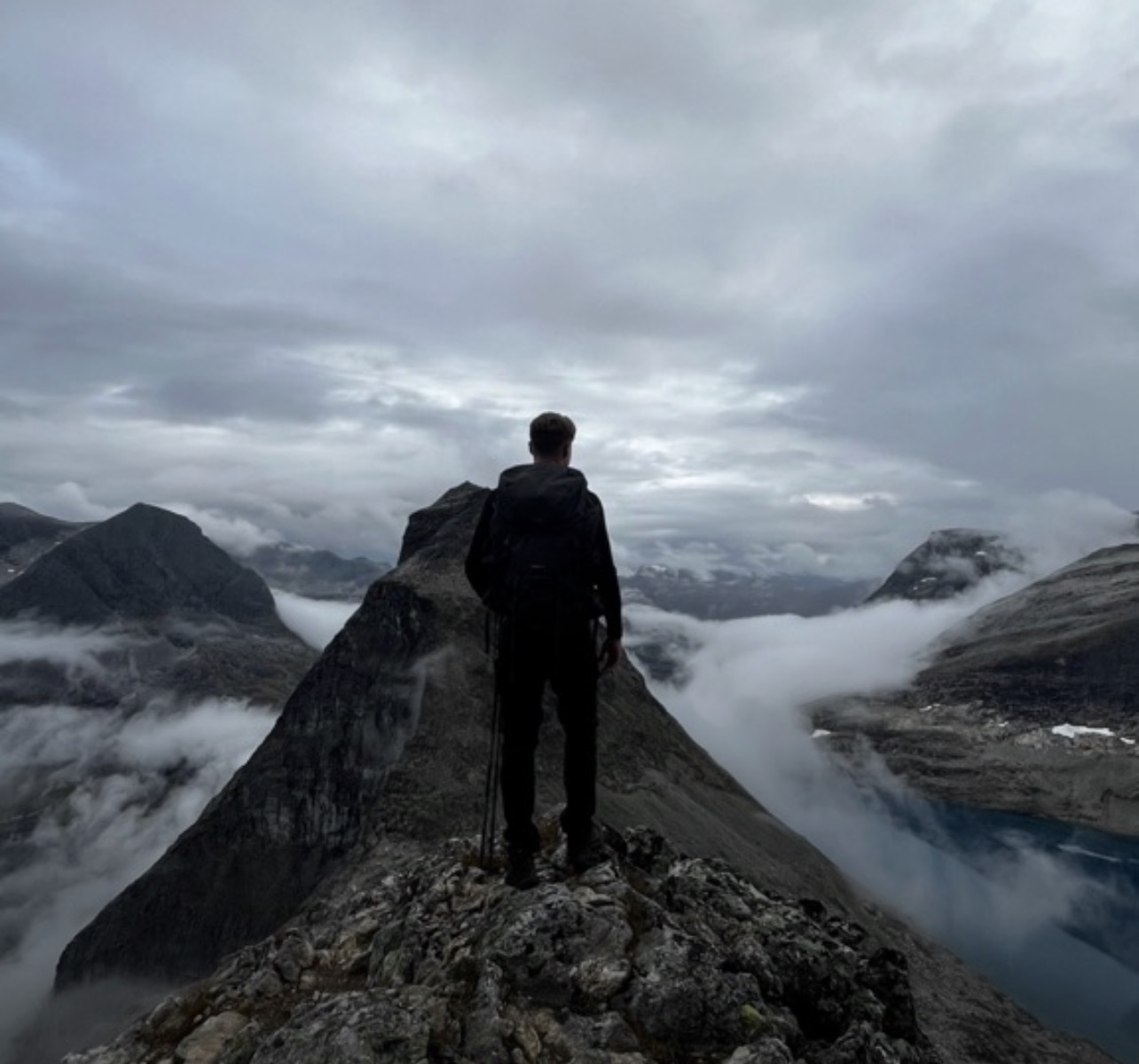 En person står på en bergstopp i Norge